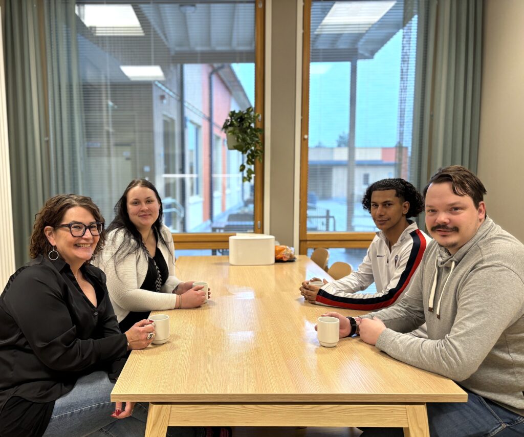 Ykkäskoti tähtirinteen työporukkaa. Henkilöstö istuu pöydän ääressä kahvittelemassa ja hymyilevät