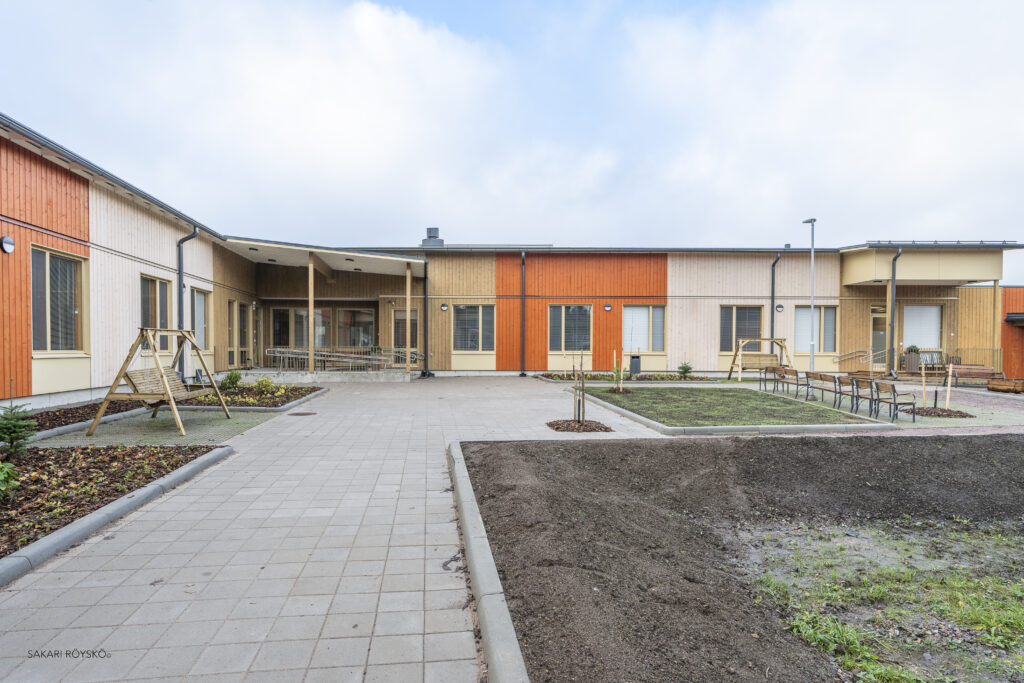 Ykköskoti Tähtirintee yksikkö ulkoapäin. Värikäs yksikerroksinen rakennus ja piha, jossa kalusteita.