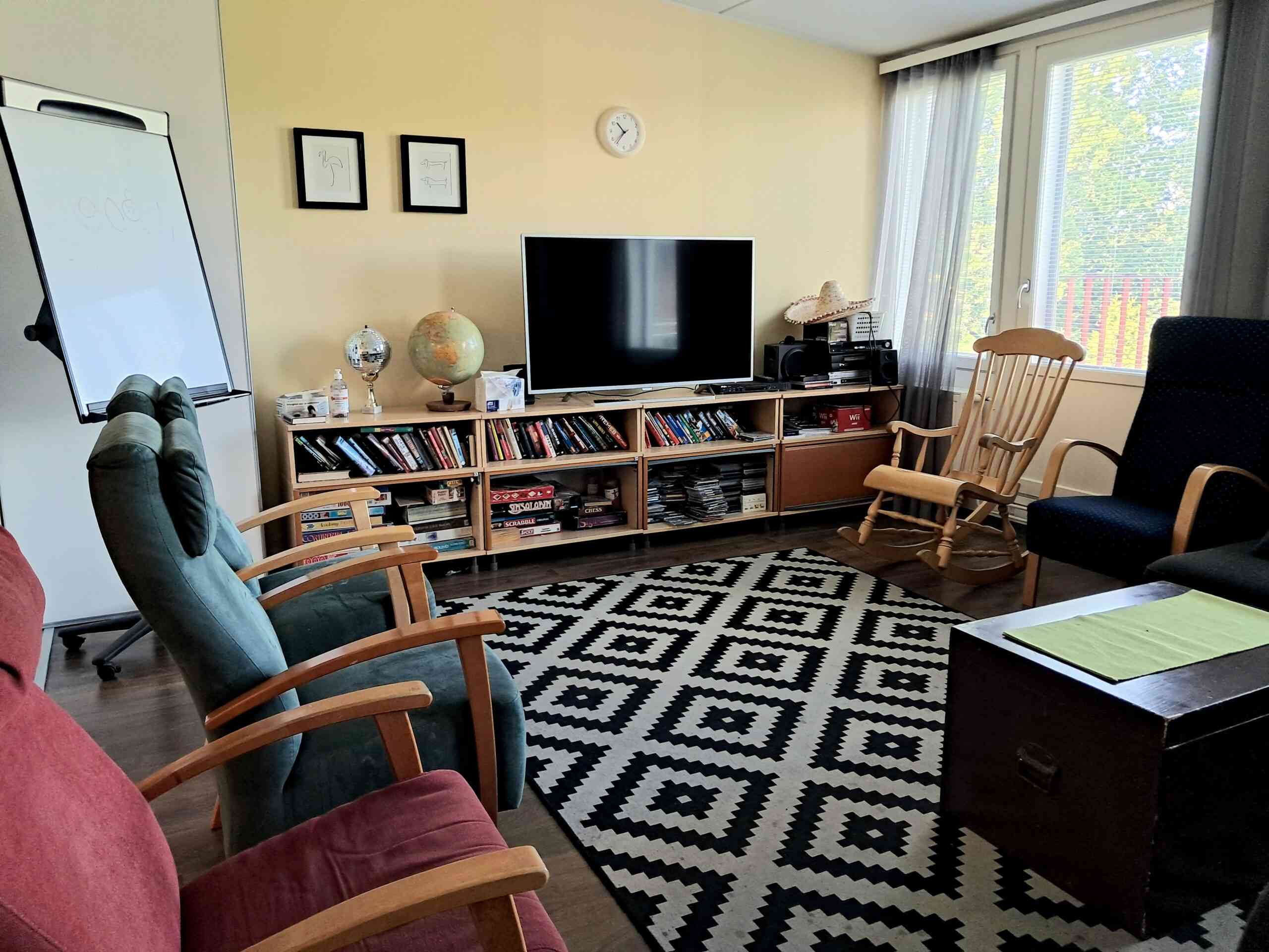 Yksikkö sisältä kuvattuna, olohuone jossa penkkejä ja televisio